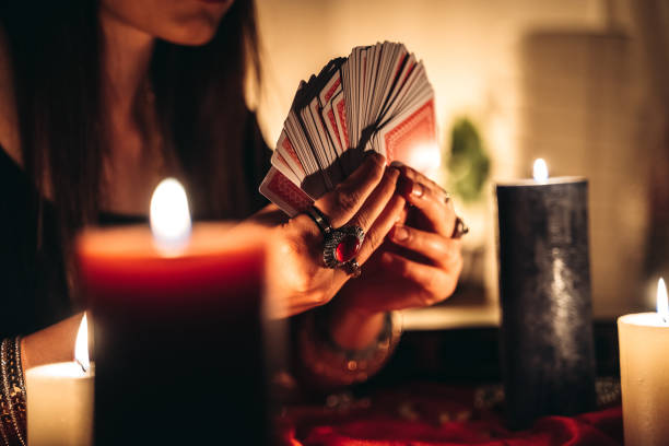 Young female fortune teller is looking into tarot cards